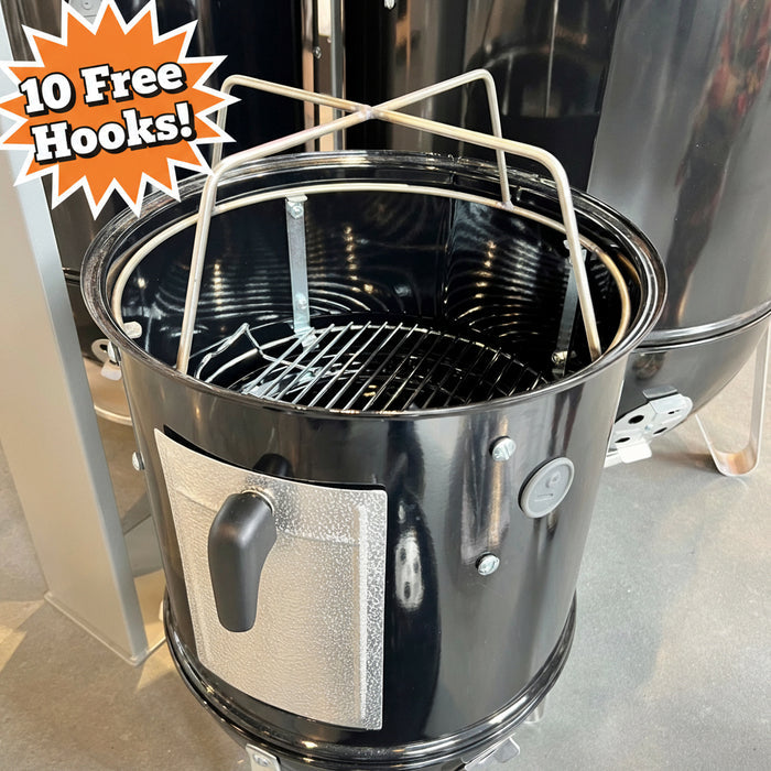Black charcoal grill with a metal basket on top, placed indoors.