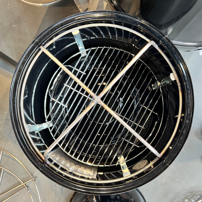 Barbecue grill with a metal grate inside on a countertop.
