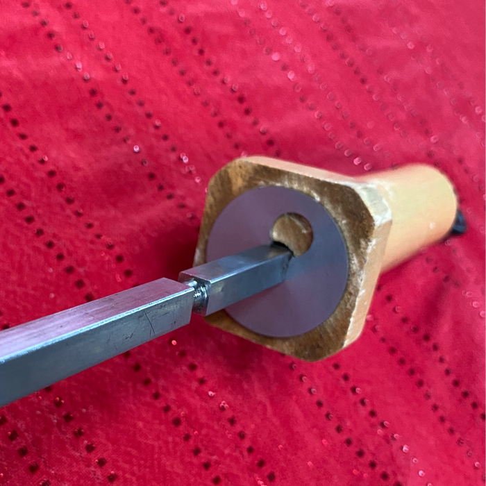 Wooden tool with a metal blade on a red textured background