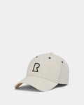 The ARSENE - 9422504 Iceland by Rudsak is a beige unisex baseball cap with a curved brim, bold black outlined R on the front, and black ventilation eyelets. This adjustable cap is shown against a plain white background.
