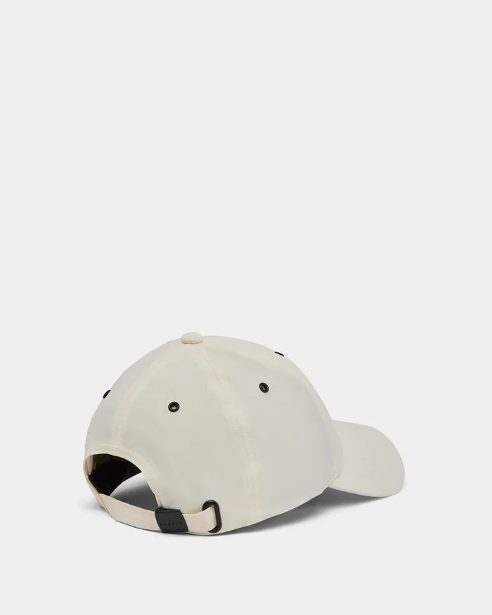 A cream ARSENE - 9422504 Iceland unisex baseball cap by Rudsak shown from the back, featuring a fabric strap with black metal clasp for adjustment and black embroidered eyelets on a plain white background.