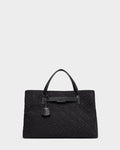 The Rudsak ASMINE - L325005 Black tote features an embossed monogram pattern, two top handles, a leather strap detail, and a hanging leather tag, shown on a plain light grey background.