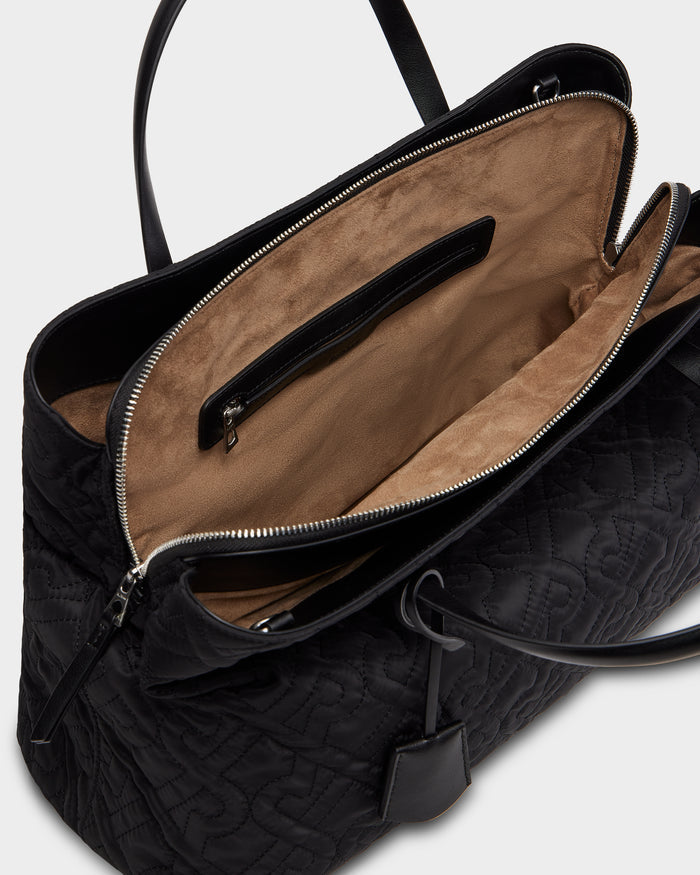 The ASMINE - L325005 Black by Rudsak is a black tote with quilted details, top zipper closure, and a roomy tan suede interior featuring a zippered pocket and leather trim.
