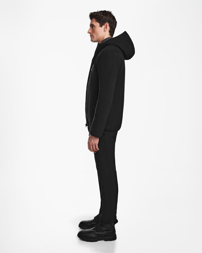 A man in profile faces left, wearing the Rudsak BILLY - U524501 Black M polar fleece hoodie with black pants and boots, set against a plain white background.