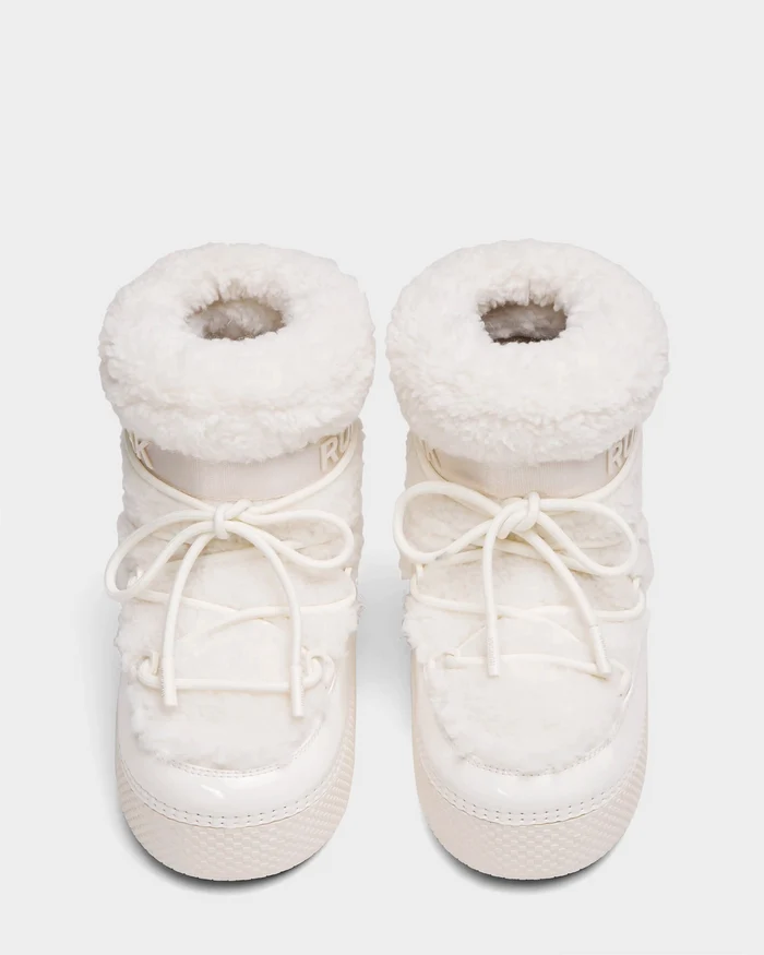 The Rudsak KATHY Y - 1224500 Iceland boots are white, fluffy, water-repellent winter boots with thick soles and front laces. Seen from above on a light background, they feature a cozy, padded, and textured design.
