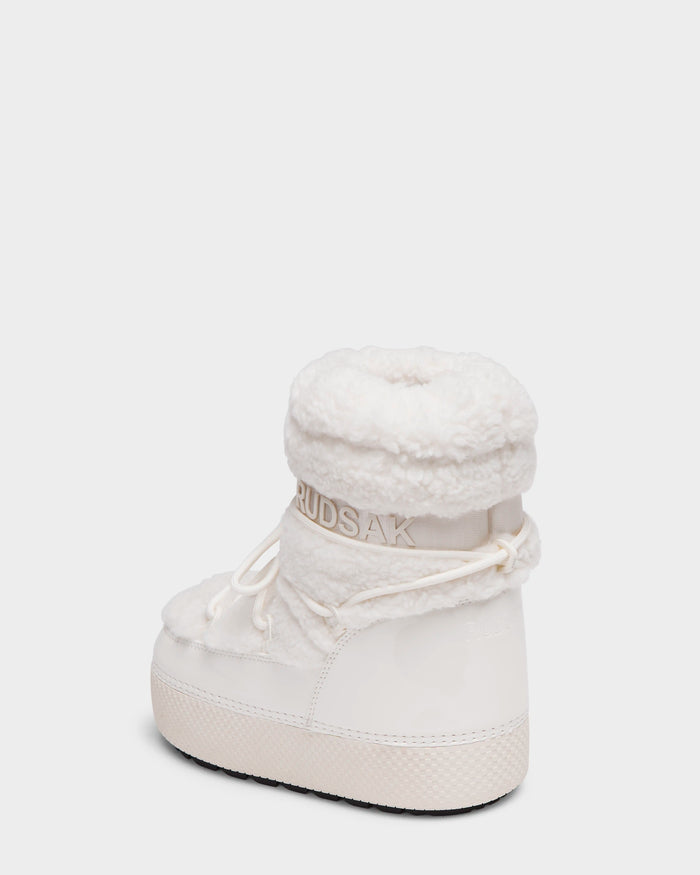 The Rudsak KATHY Y - 1224500 Iceland is a white winter boot with a plush fleece exterior, round toe, lace-up detail, and RUDSAK branding on the heel. These water-repellent boots are shown against a plain white background.