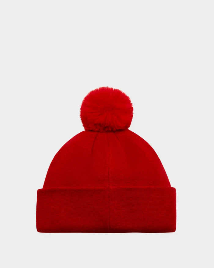The KRISS - 9424500 Flame Red by Rudsak is a bright red unisex ski tuque with a folded brim and large pom-pom, perfect for après-ski style, shown against a plain white background.