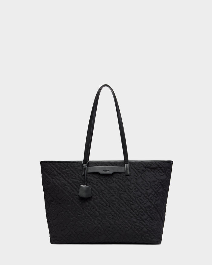 The Rudsak LIVORNO - L325007 Black is a luxury tote with two long handles, a subtle embossed monogram pattern, and a small leather tag on one handle, shown against a plain light gray background.