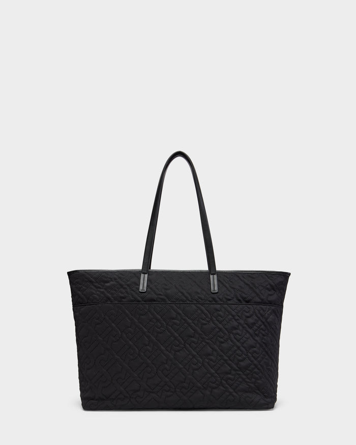 The LIVORNO - L325007 Black by Rudsak is a large quilted tote featuring an embossed monogram pattern and two long handles, shown against a plain light background.