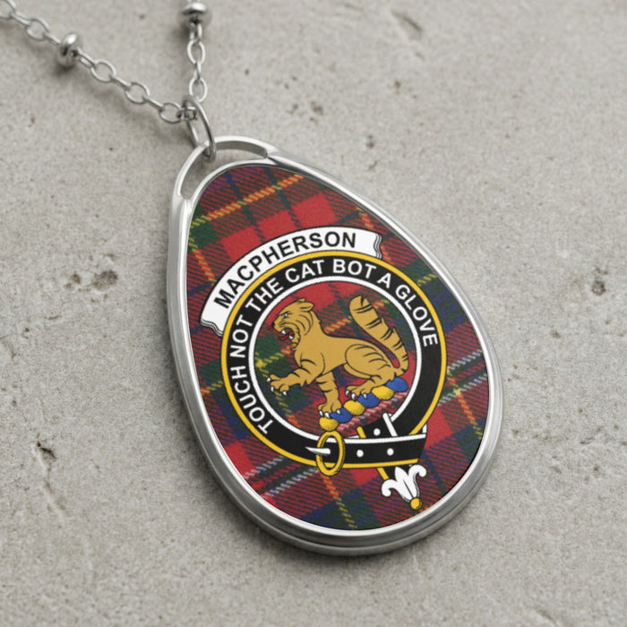 Macpherson clan Scottish tartan necklace with clan crest and Touch Not The Cat Bot A Glove motto on tartan background