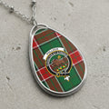 Pollock clan Scottish tartan necklace with clan crest and Audacter Et Strenue motto on tartan background