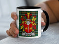 White mug with black rim, featuring a green tartan pattern and the Sloane family crest.
