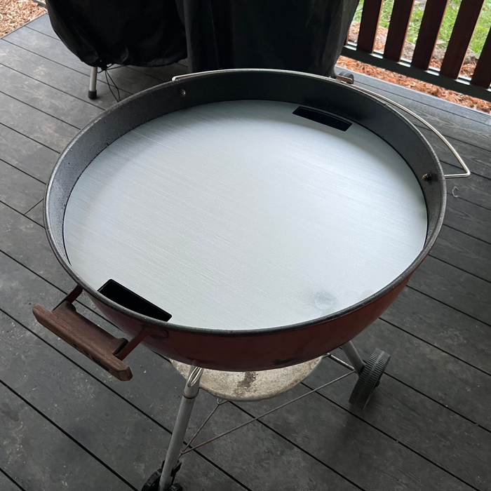Stainless smash plate fitted to a weber kettle with a charcoal deck in the background