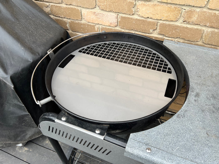 Angled view of the grill plate fitted to a weber kettle