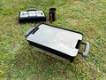 both half smash plates fitted to a weber go anywhere with a nice green grass backgrounf