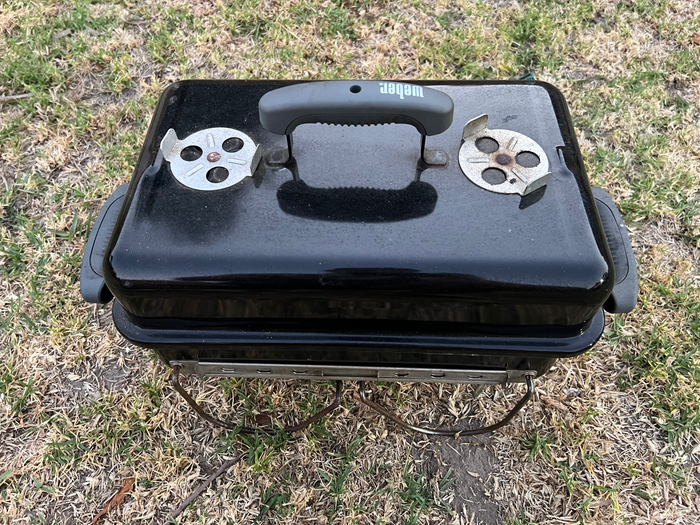 Weber GA with grass background, lid on and all parts inside