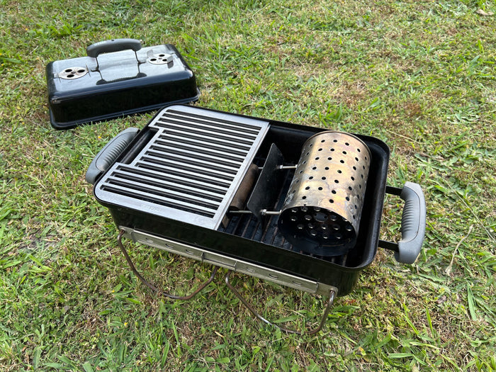 half grill shown fitted to a weber GA with a chimney starter on a grass background